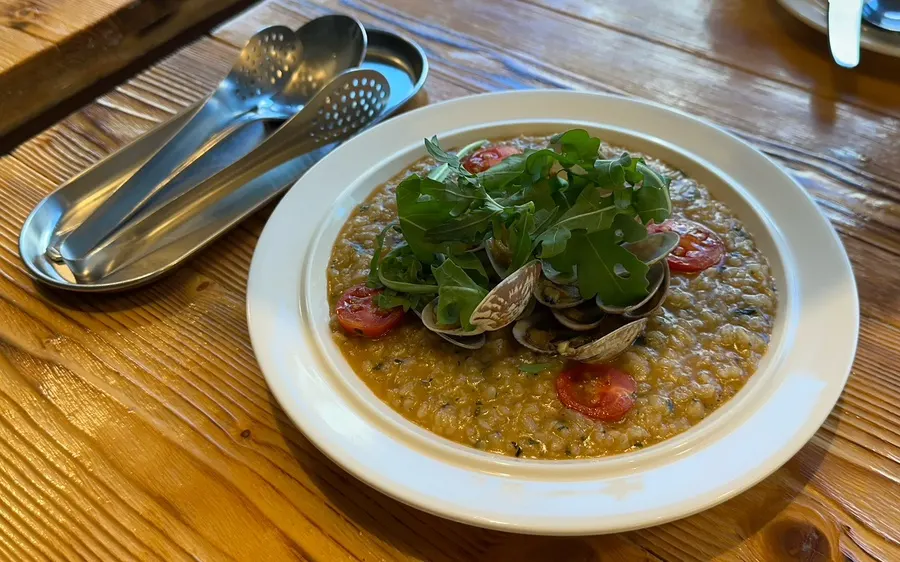 A plate of clam risotto in shrimp bisque sauce