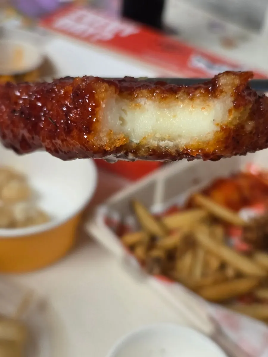 Cheese stick pulled apart, showing melted cheese inside