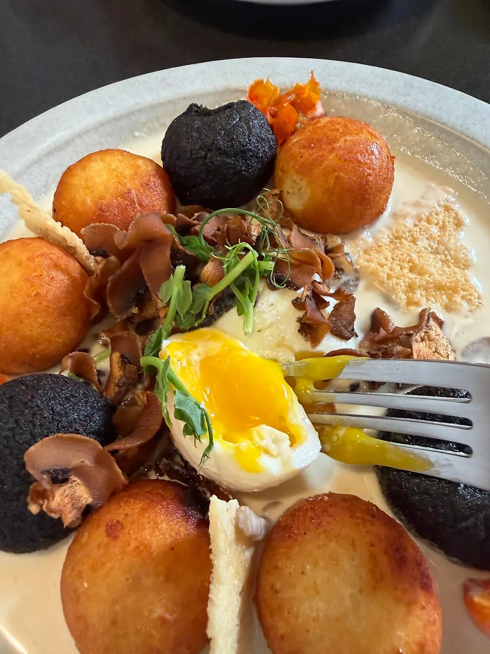Poached egg atop gnocchi cut in half