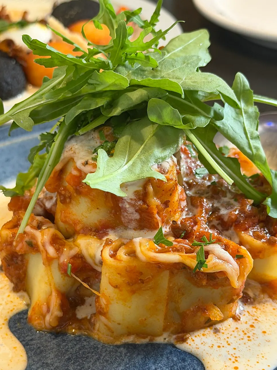 Close-up of fresh pasta lasagna topped with arugula