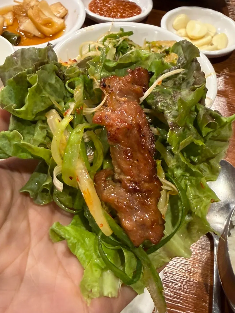 焼いた豚カルビを一切れ取った様子