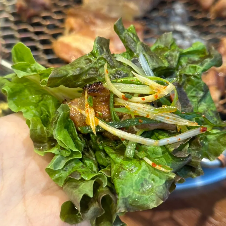 A piece of pork rib in a lettuce wrap