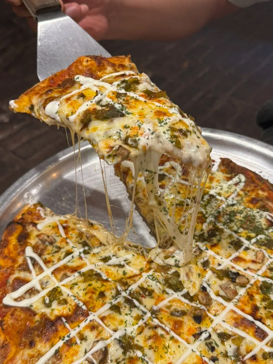 Cheese-pull slice of the lasagna pizza