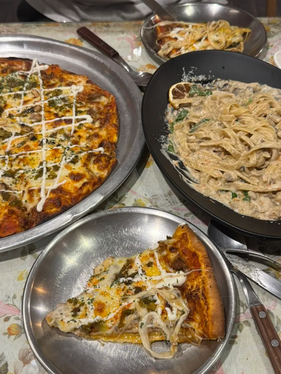 Table with both pasta and lasagna pizza together