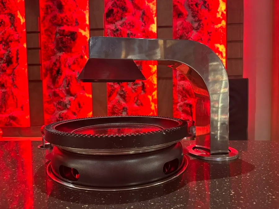 Brazier in front of the bar seats with meat set on top