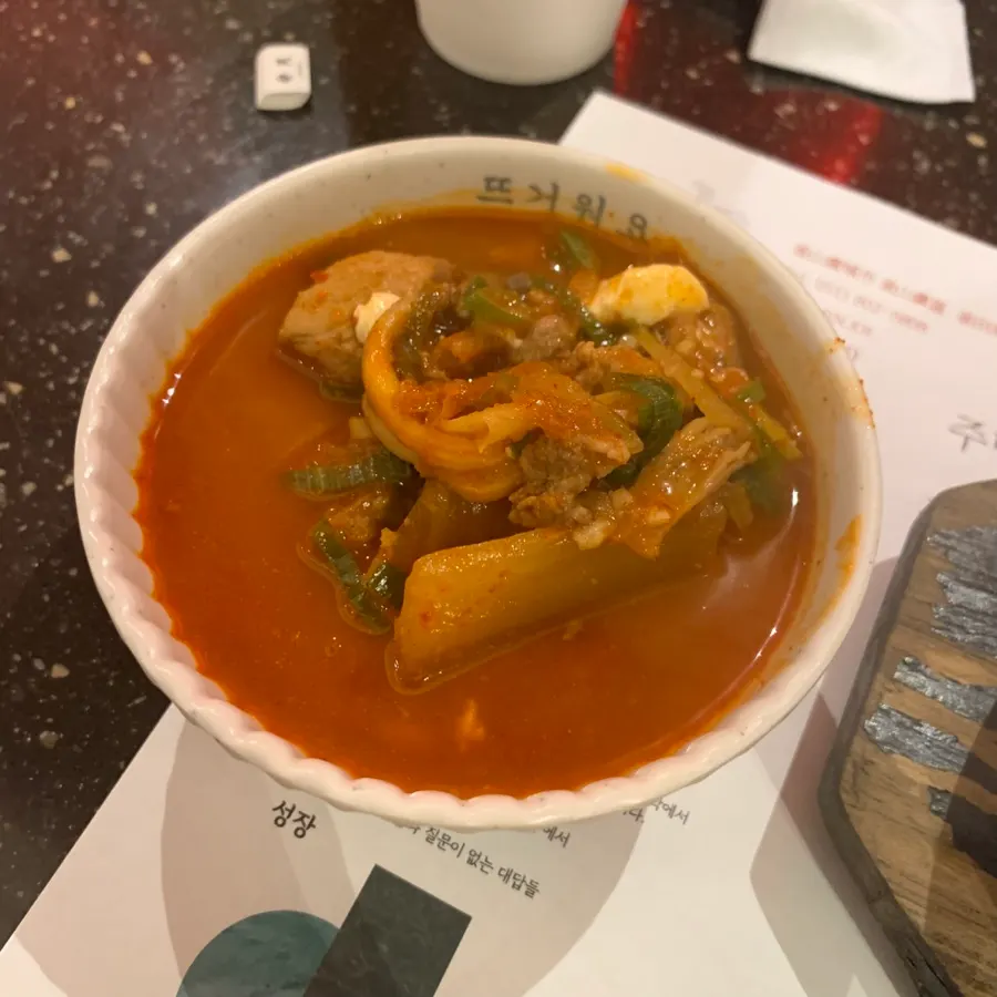 Table spread with soft tofu stew and grilled meat