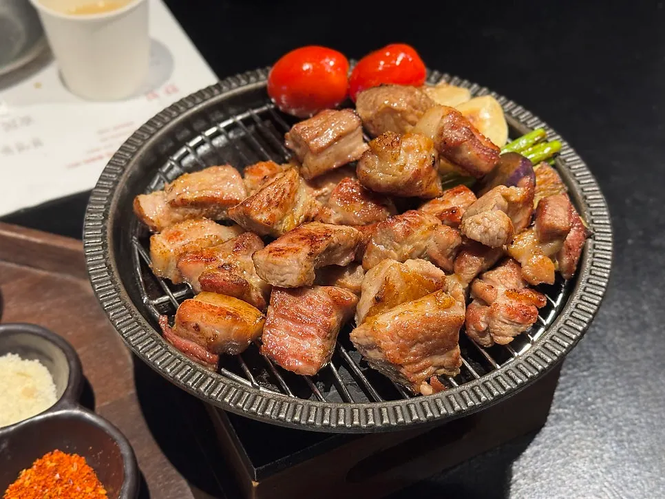Fully grilled meat placed on a mini brazier