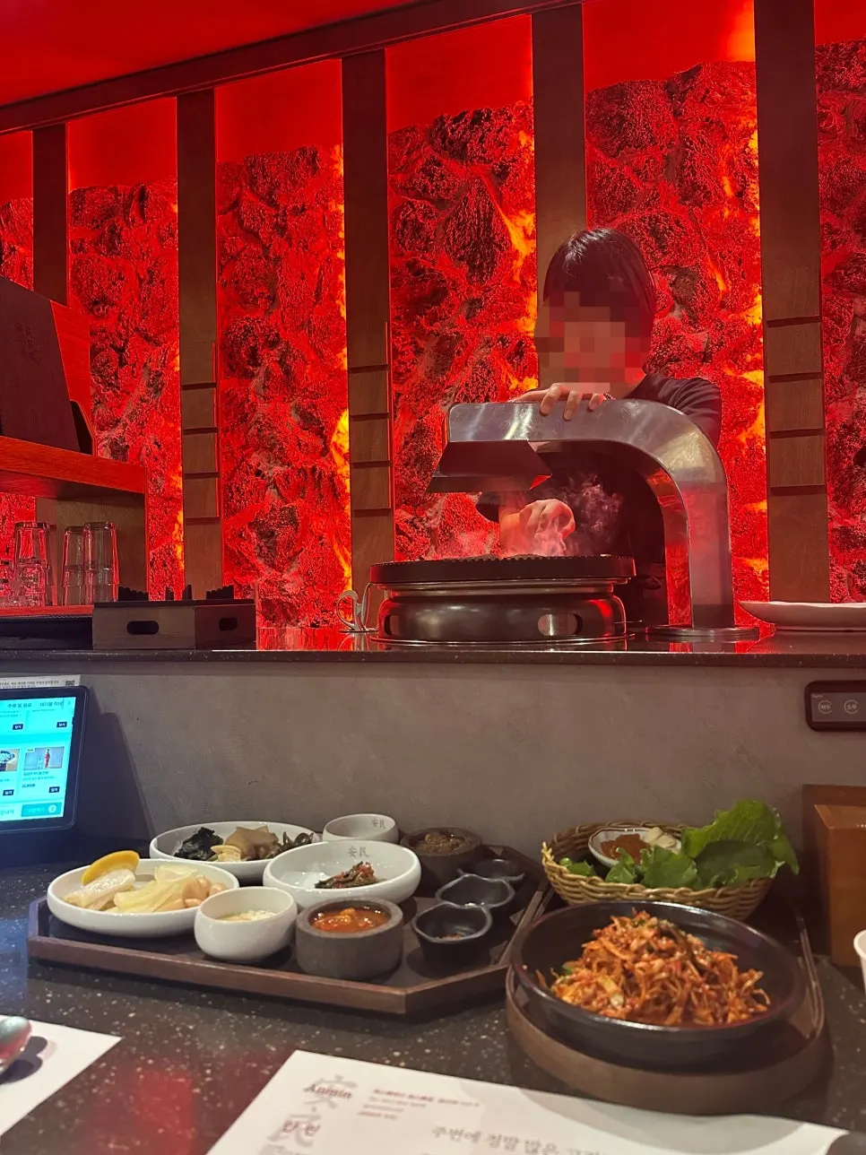 Staff grilling meat tableside at Anmin Busan