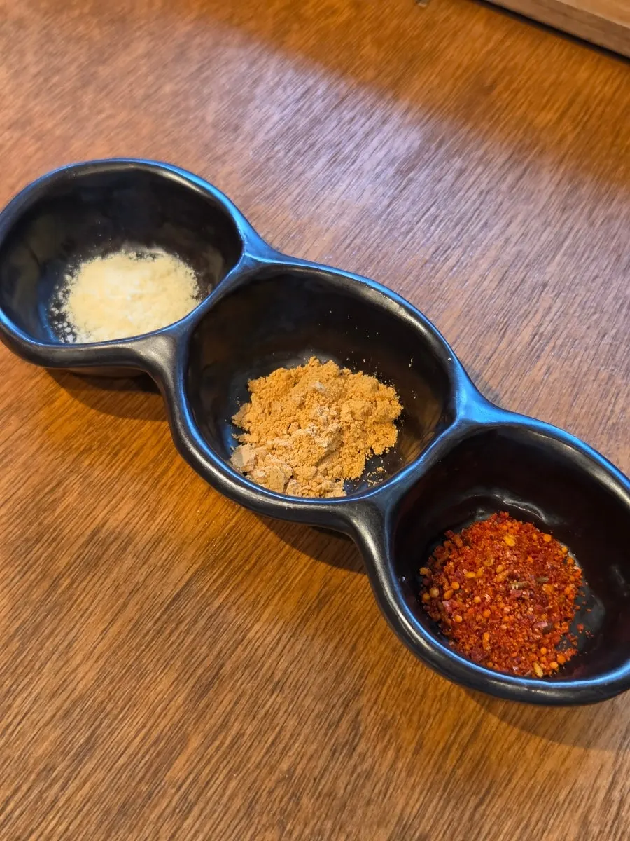 Accompanying sauces including curry bean powder, cumin, and pine pollen salt