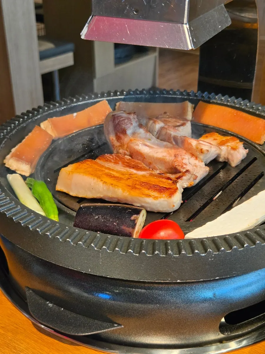 Pork neck and pork skin cooking on the grill