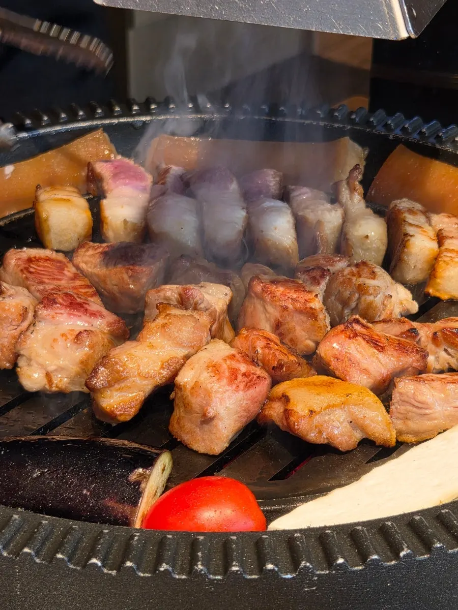 A grilled piece of pork dipped in sauce
