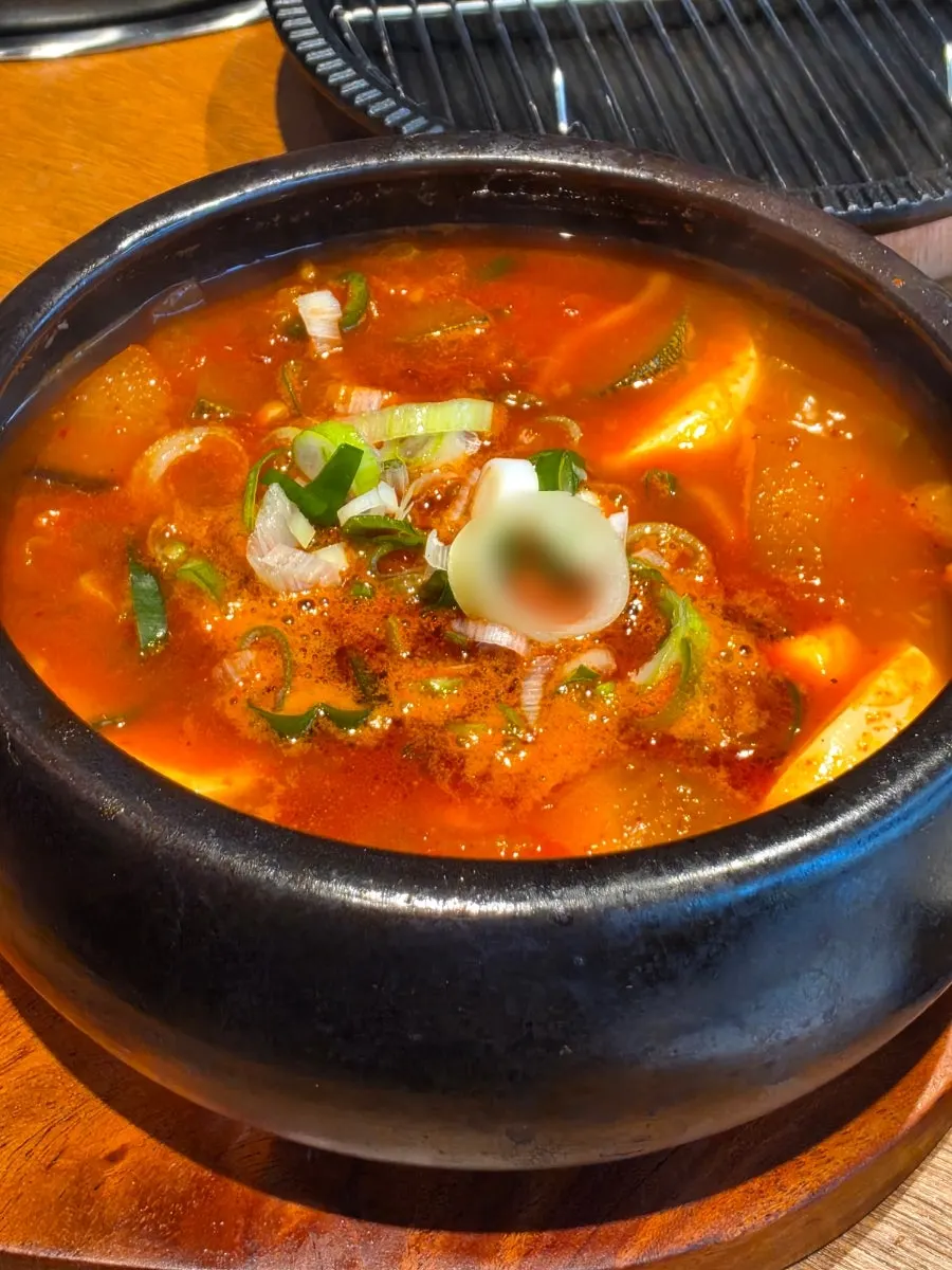 Table setting with sundubu jjigae served in a jar