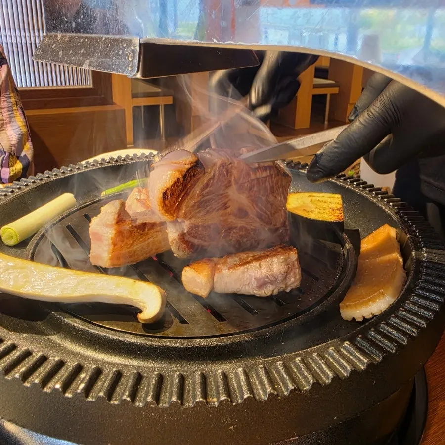 Samgyeopsal and pork neck cooking over charcoal
