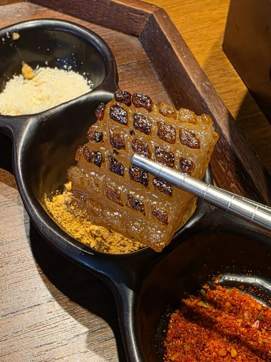 A piece of samgyeopsal dipped in sauce
