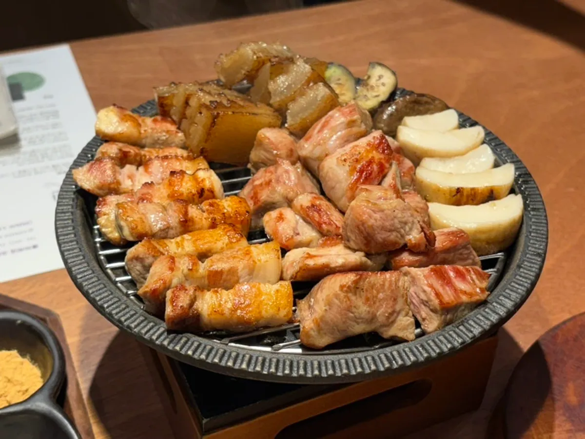 Grilled meat neatly stacked over the brazier