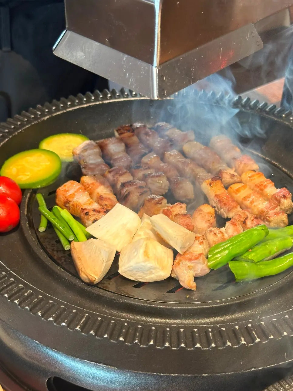 숯불 위에서 익어가는 삼겹살과 채소