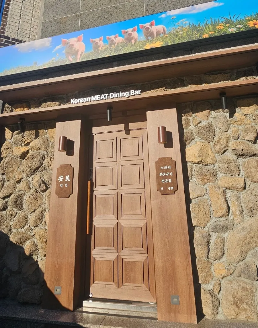 Anmin Yullyang entrance with stone wall and wood-toned door