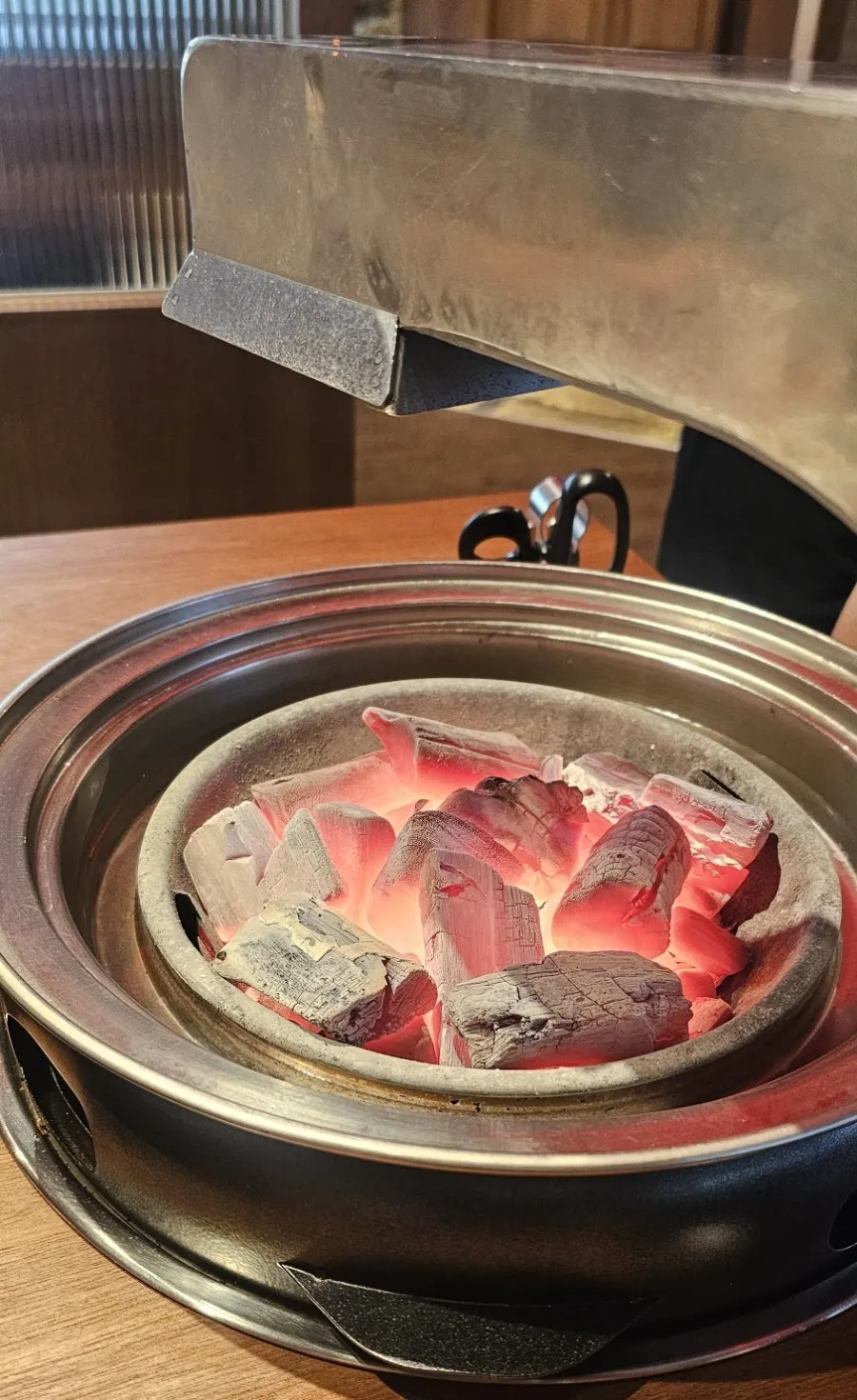 Whole pork neck with mushrooms and shishito peppers on the grill
