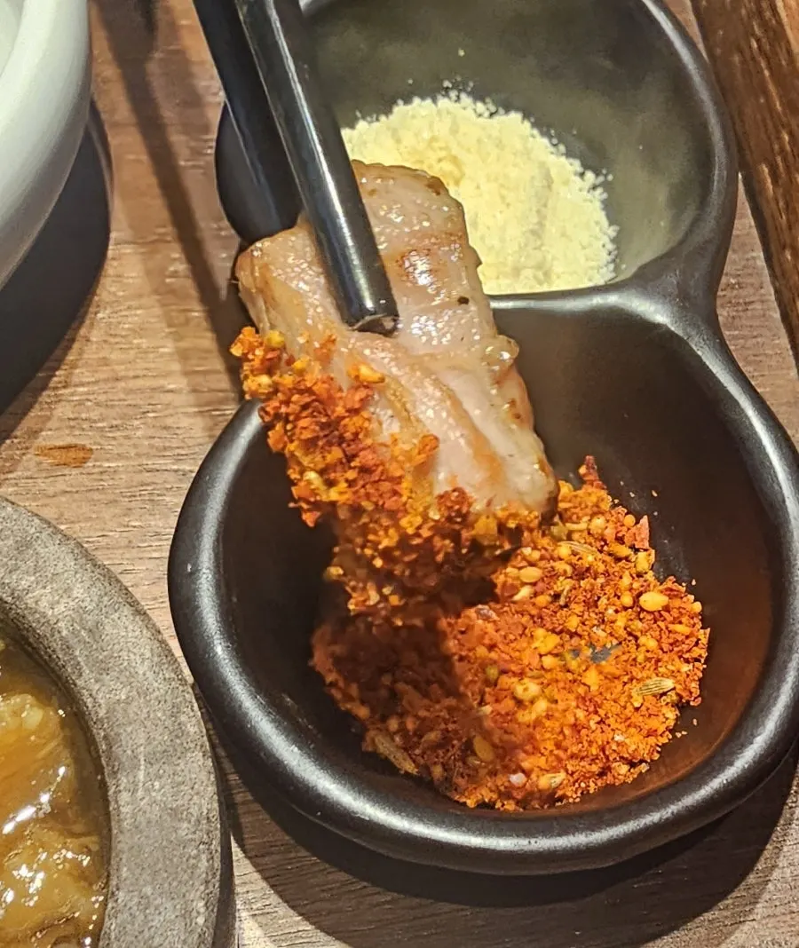 A piece of pork neck placed on seasonal pickles