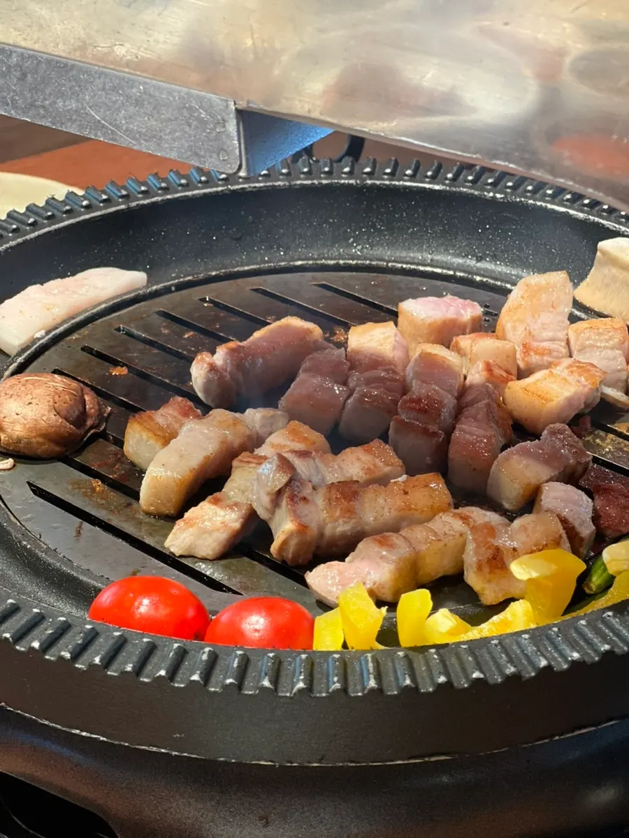 Whole pork belly grilling on the brazier
