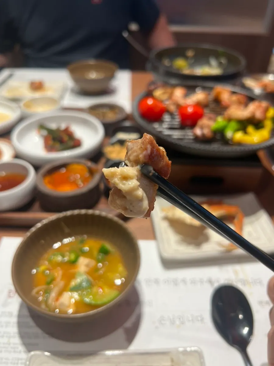Pork belly served with sauce and a cocktail