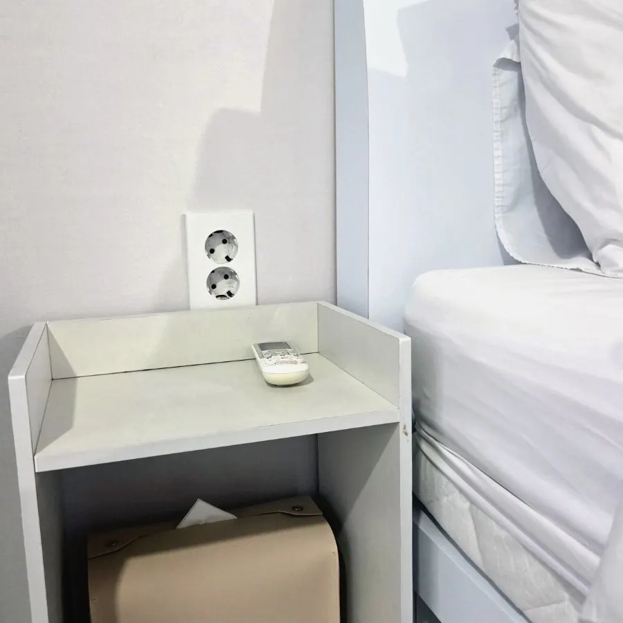 Outlet, storage space and remote control beside the bed