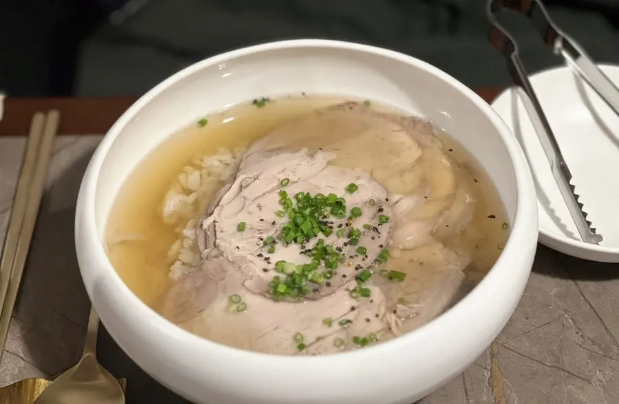 Anok's clear gomtang served in a brass bowl