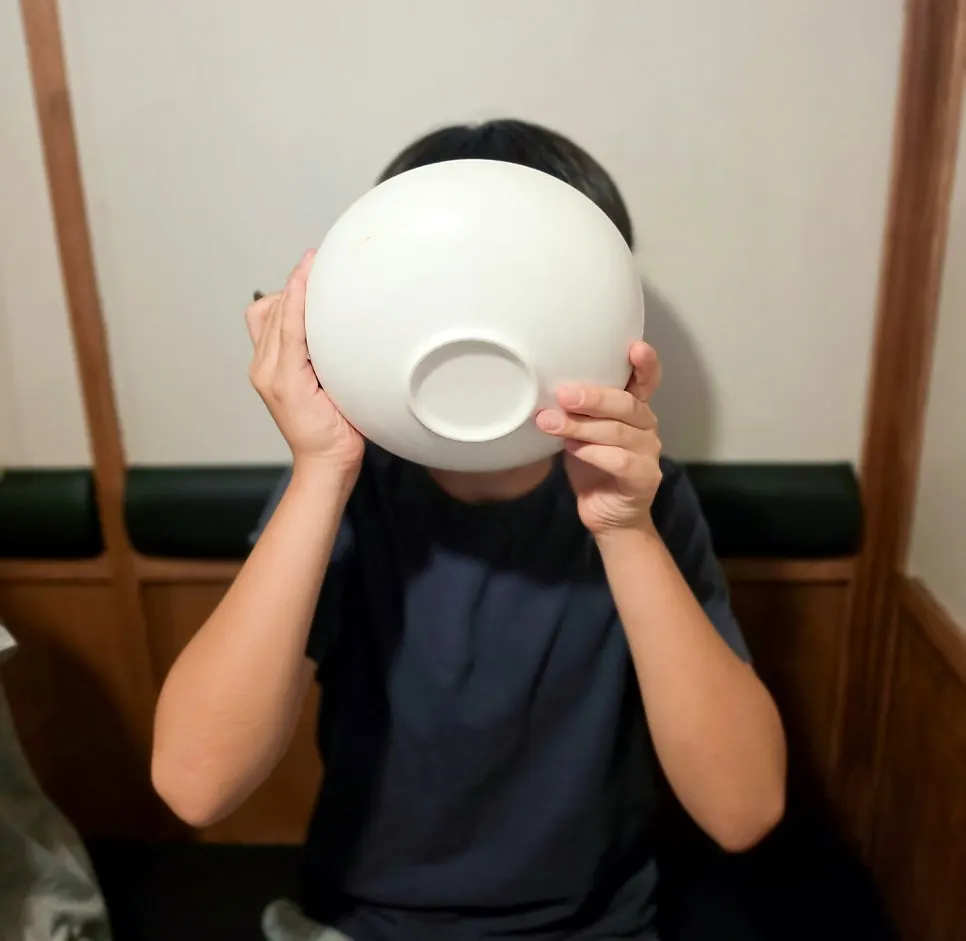 舀起牛骨湯裡肉塊的畫面