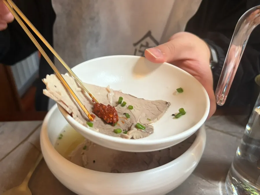 A spoonful of gomtang broth and rice