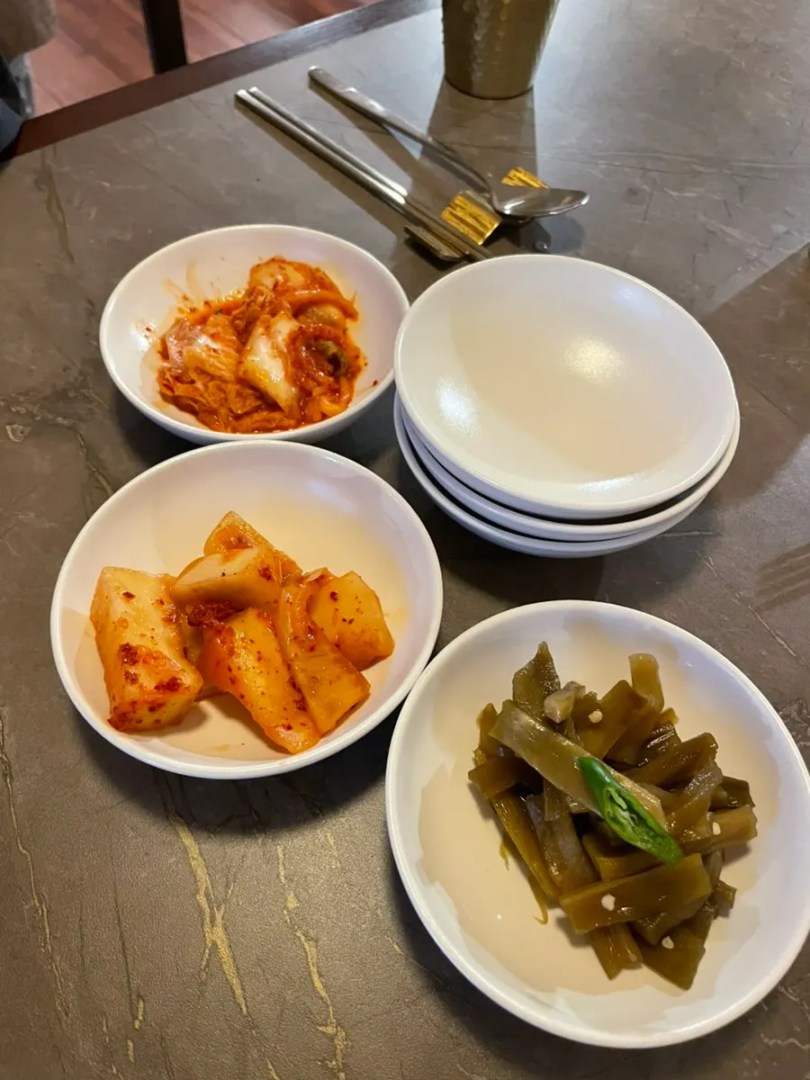 기본 반찬으로 나온 김치와 태블릿이 놓인 테이블