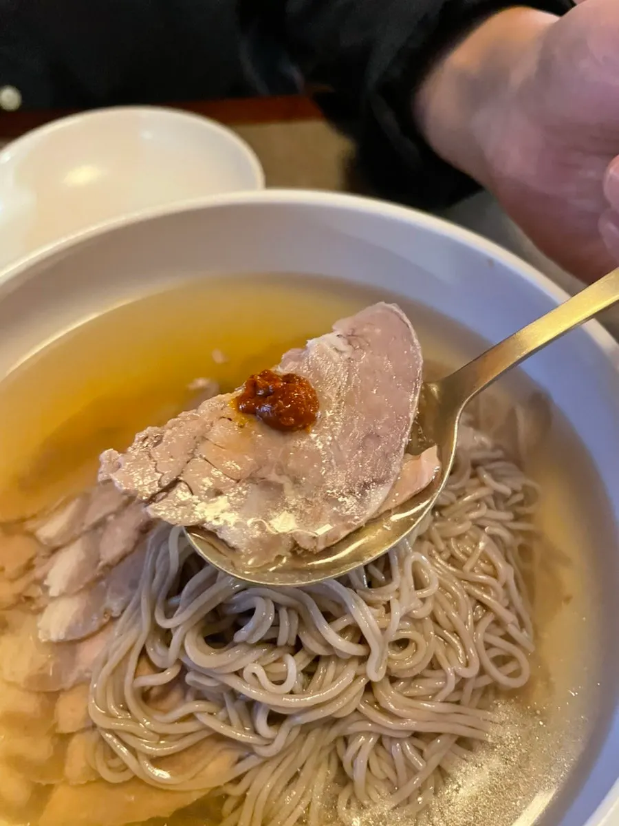양념장을 올린 평양냉면 고기 한 점