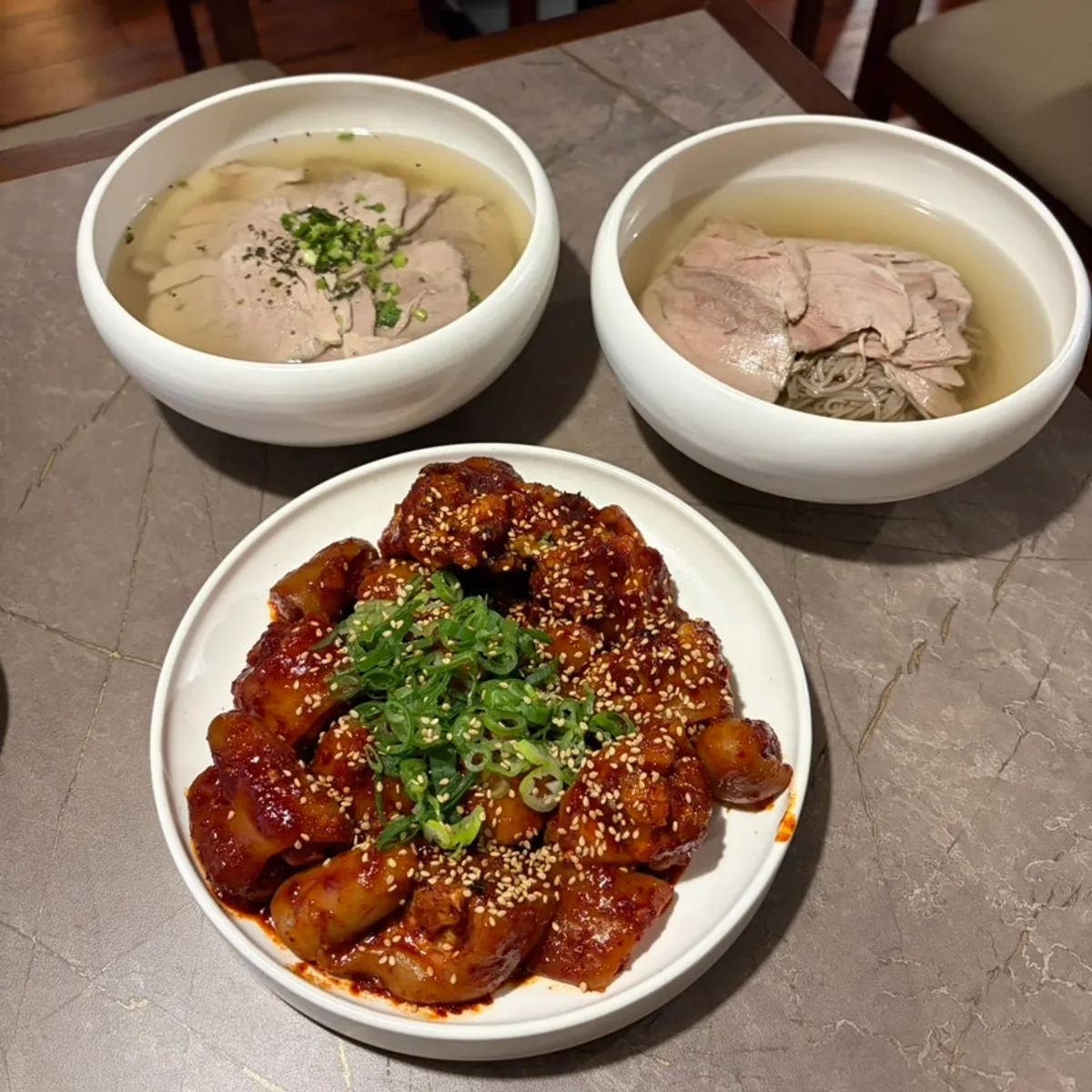 A full spread of pork tail jjim, Pyongyang naengmyeon, and gomtang guk-bap
