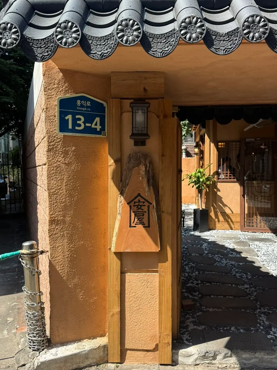 The entrance of the hanok restaurant with a wooden gate