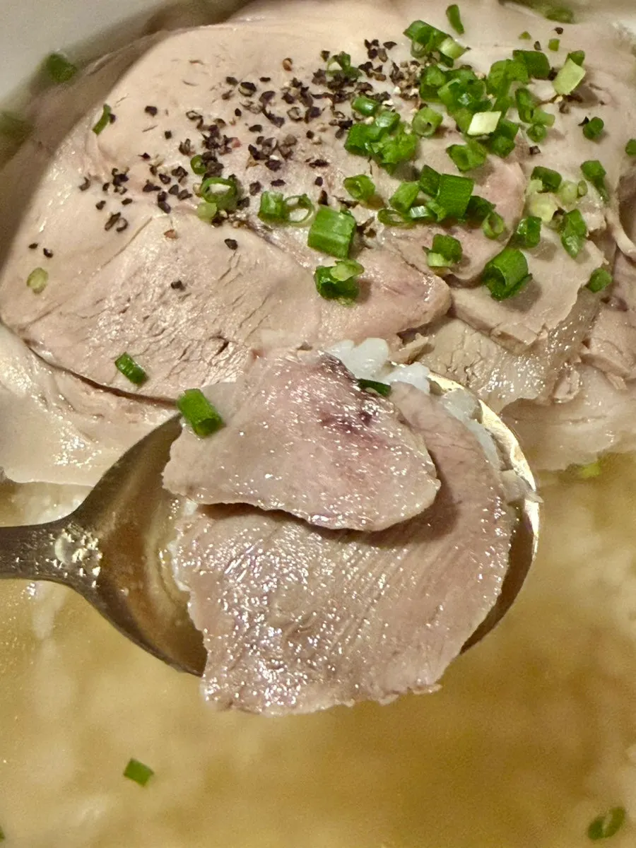 A spoonful of gomtang with meat over rice