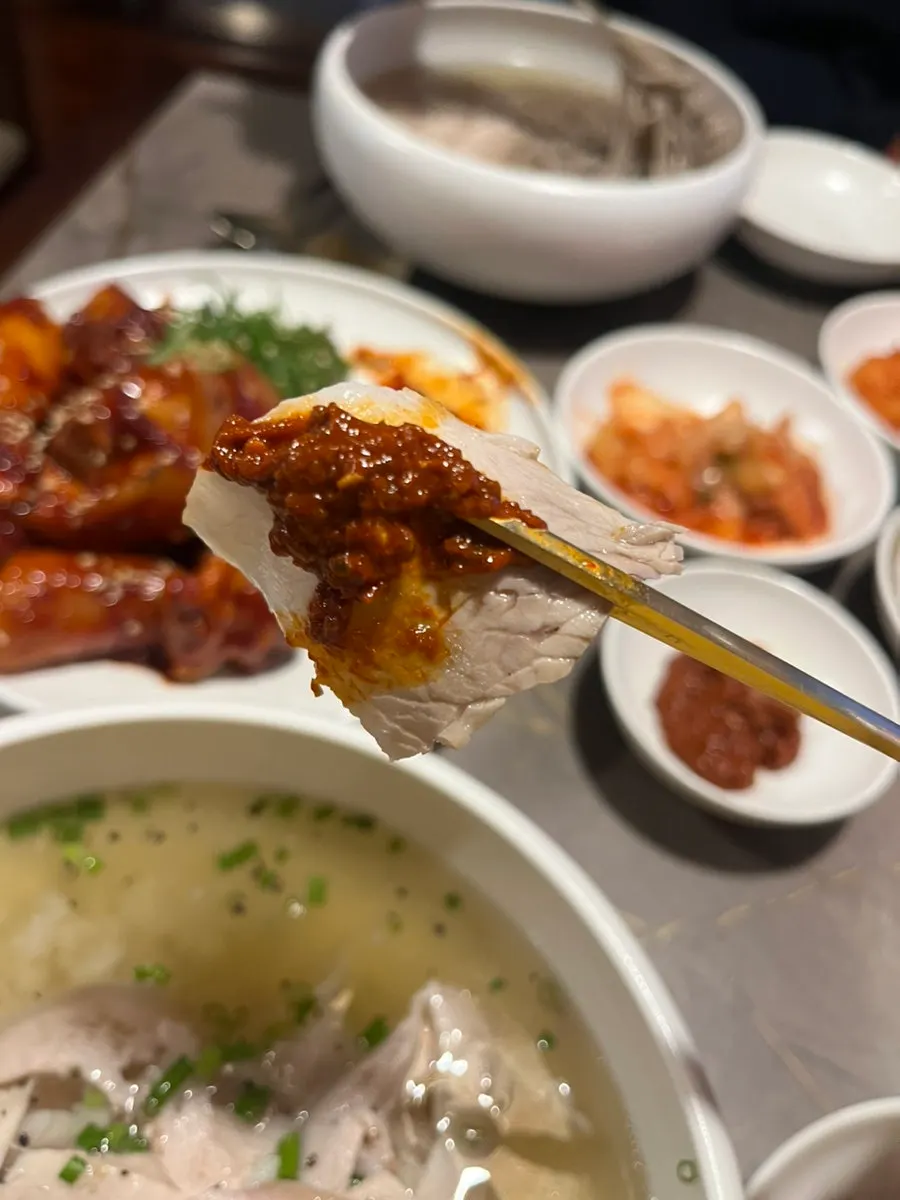 Naengmyeon noodles lifted with chopsticks