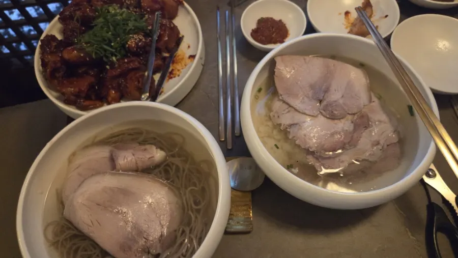 A spread of clear gomtang and Pyongyang naengmyeon at Anok