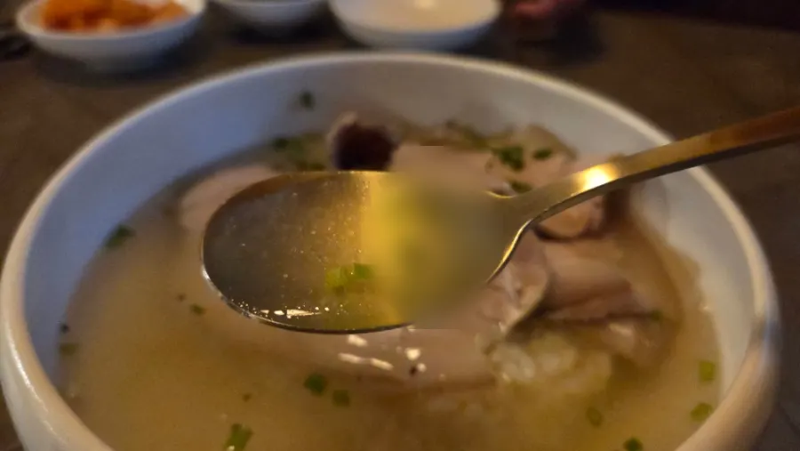 A bowl of clear gomtang topped with tender meat