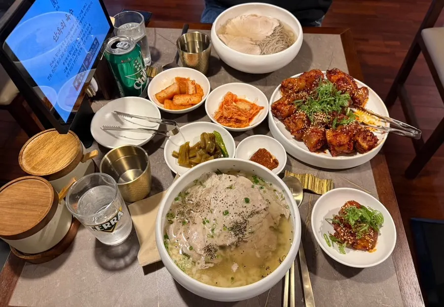 A table spread with gomtang, naengmyeon, and pork tail jjim together