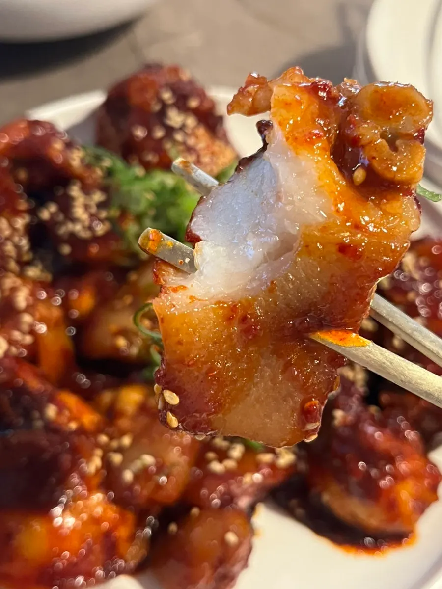 A plate of pork tail jjim topped with chili peppers
