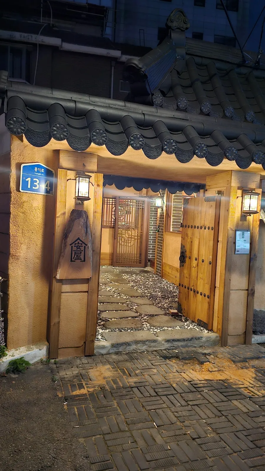 Tiled hanok gate with blue address plate