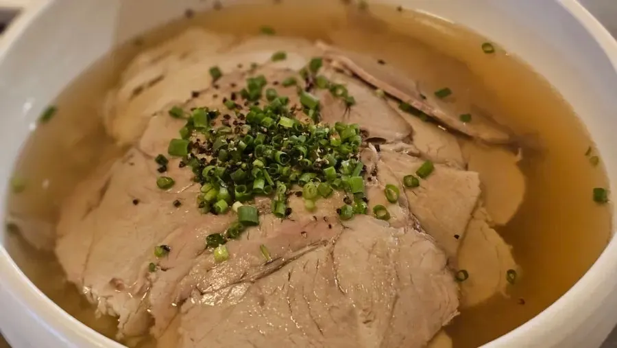 A bowl of gomtang loaded with meat garnish