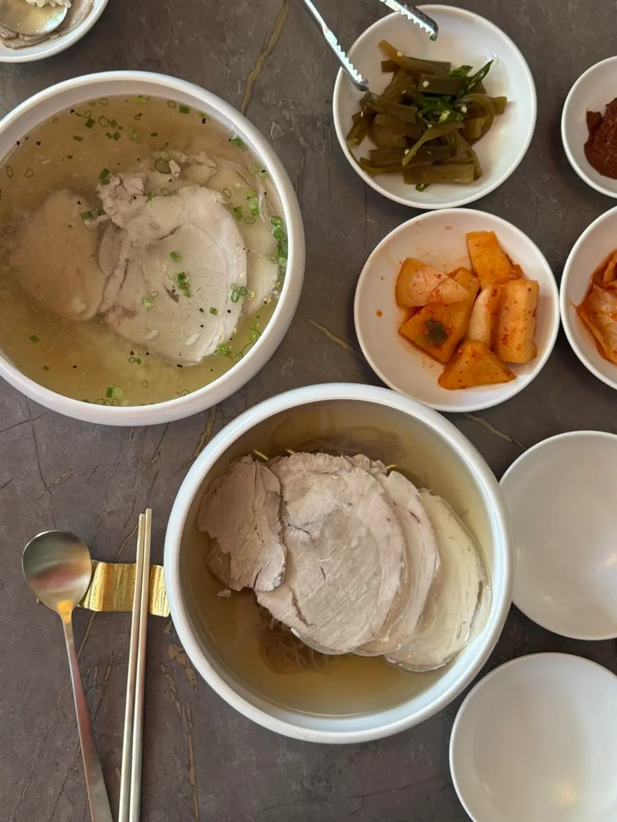 A table spread of gomtang and Pyeongyang naengmyeon at Anok