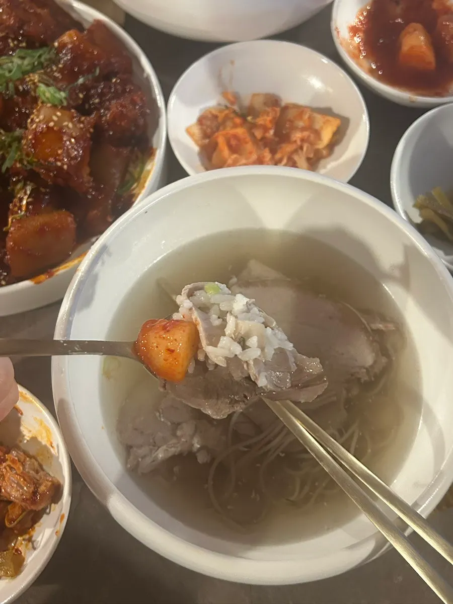 밥이 들어 있는 맑은 곰탕과 김치 반찬
