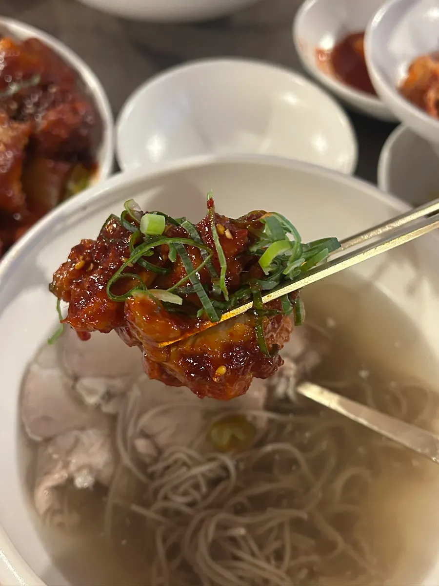 돼지꼬리찜 한 조각을 집어 든 모습