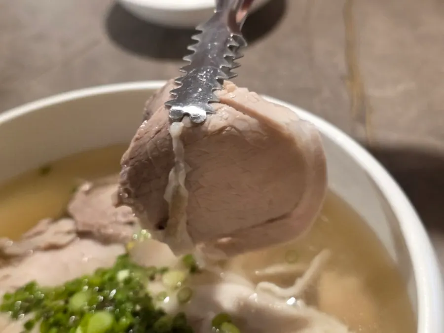 Close-up of clear pork gomtang topped with green onion