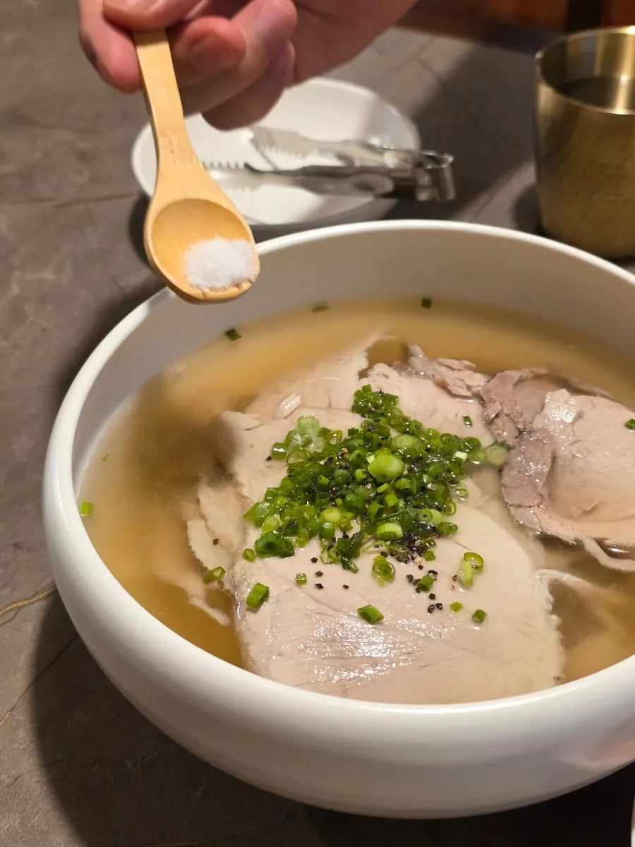 Sprinkling salt and pepper into pork gomtang