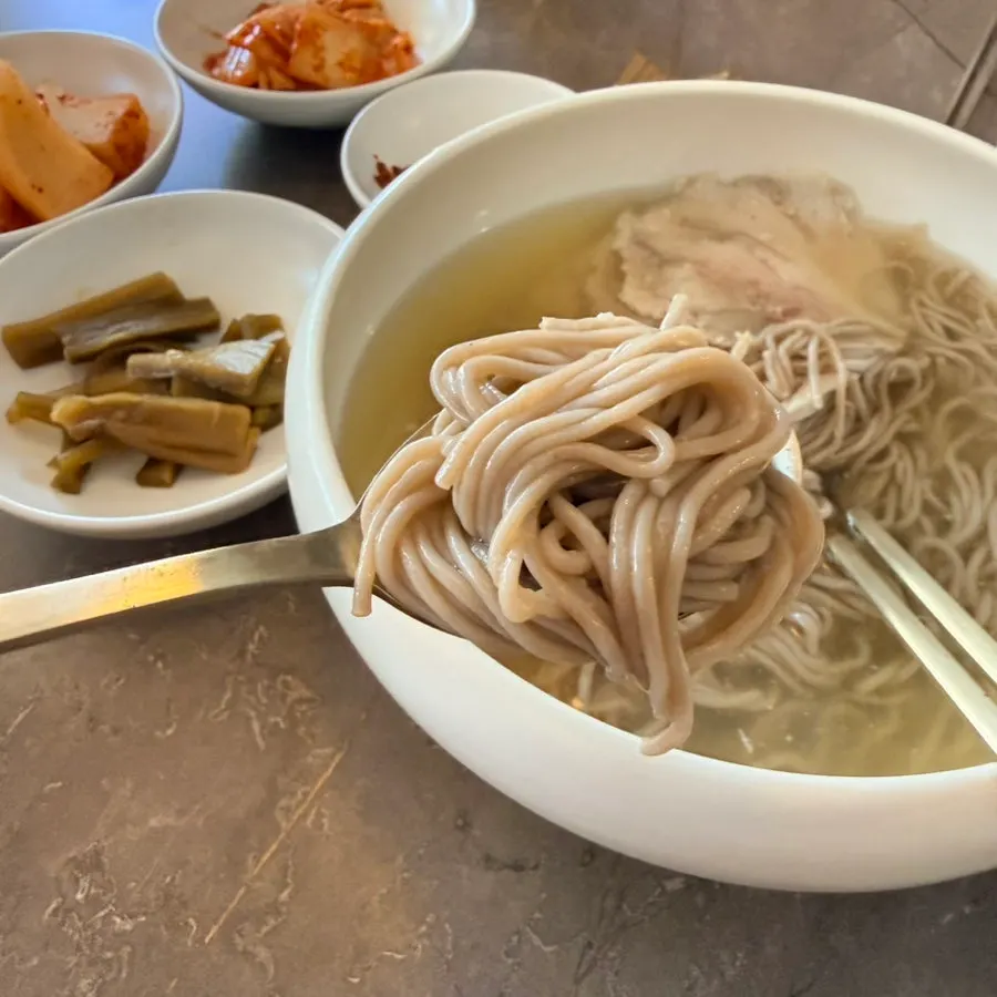 Close-up of Pyongyang naengmyeon topped with sliced meat