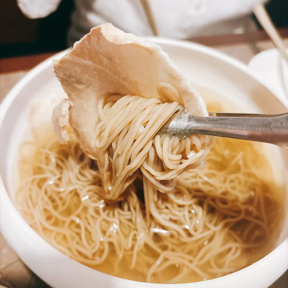 Picking up a piece of pork tail jjim with chopsticks