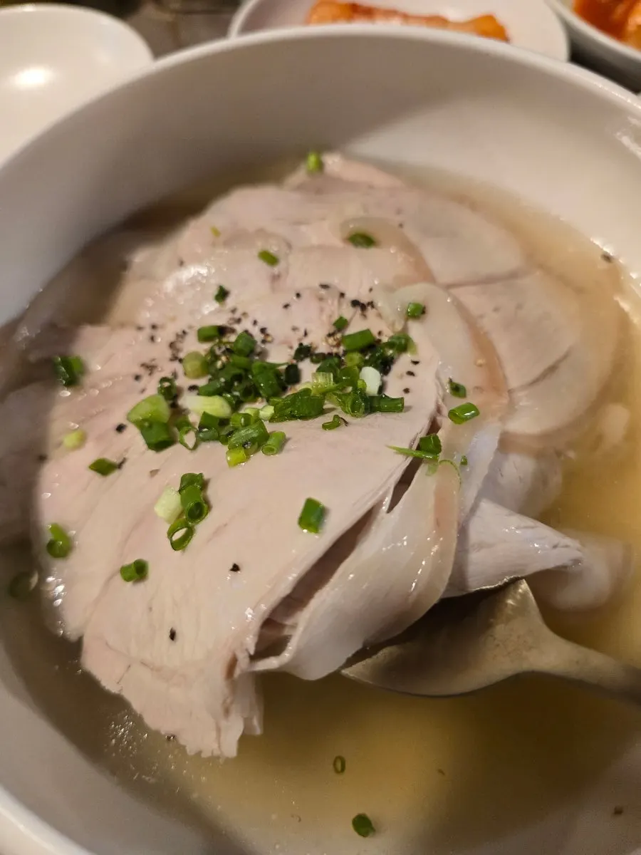 コムタンの中の肉をすくい上げた様子