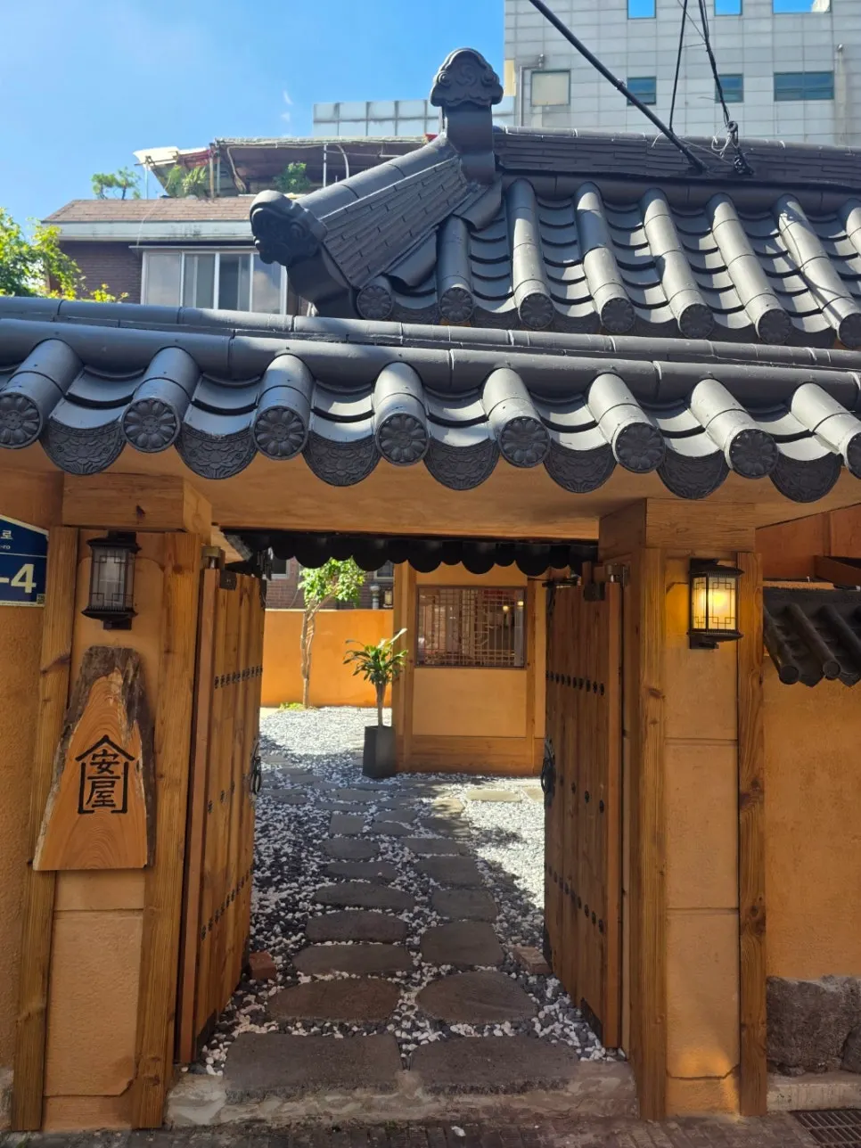 Anok's tiled roof set between modern buildings
